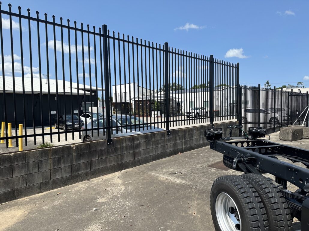 2400mm high black spear top fence mounted on top of concrete retaining wall - QFence