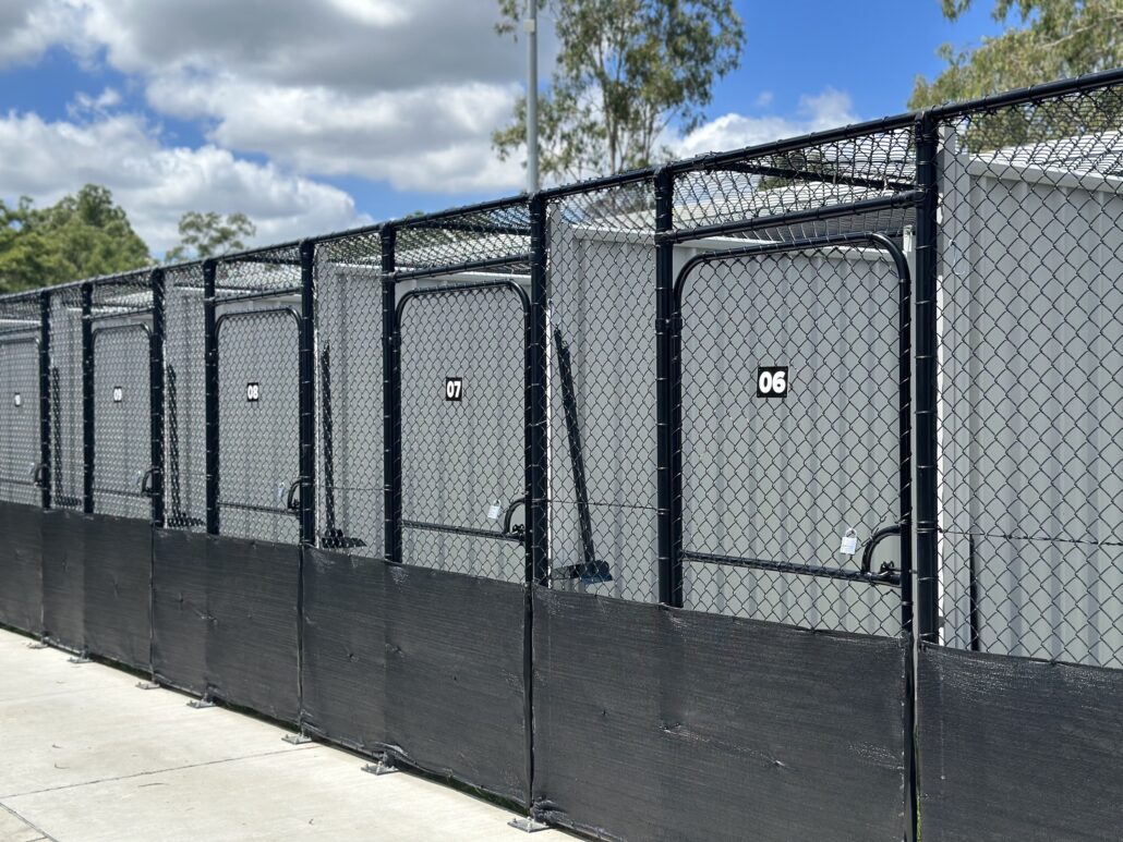 Chainwire dog enclosures with chainwire  roof and 2100mm high colorbond dividers with posts set into block wall QFence